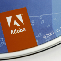 Close-up of Adobe Systems logo on blue Photoshop CS6 disc